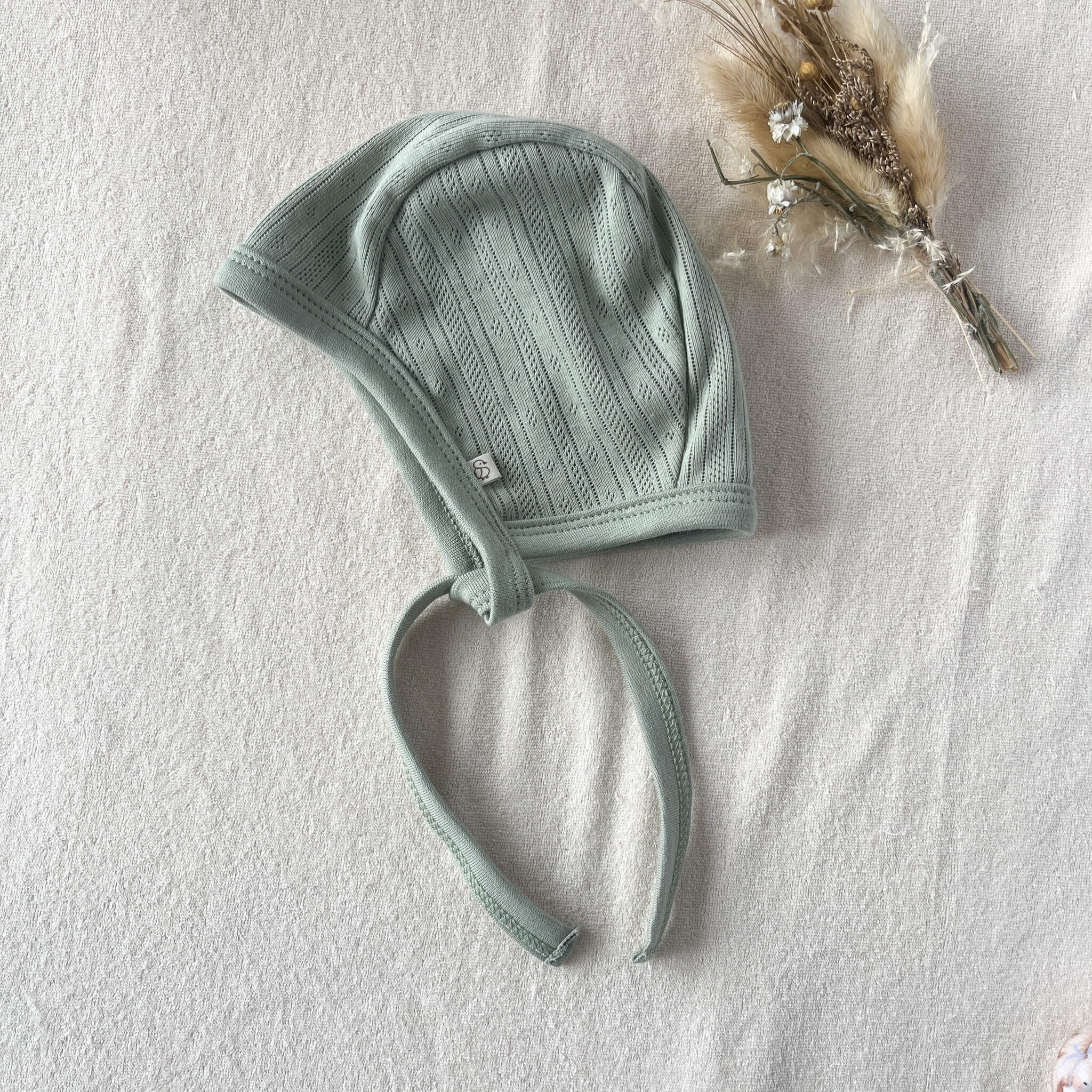 Béguin bébé en pointelle coton vert sauge posé à plat – attaches longues fait main Maison Piou Piou